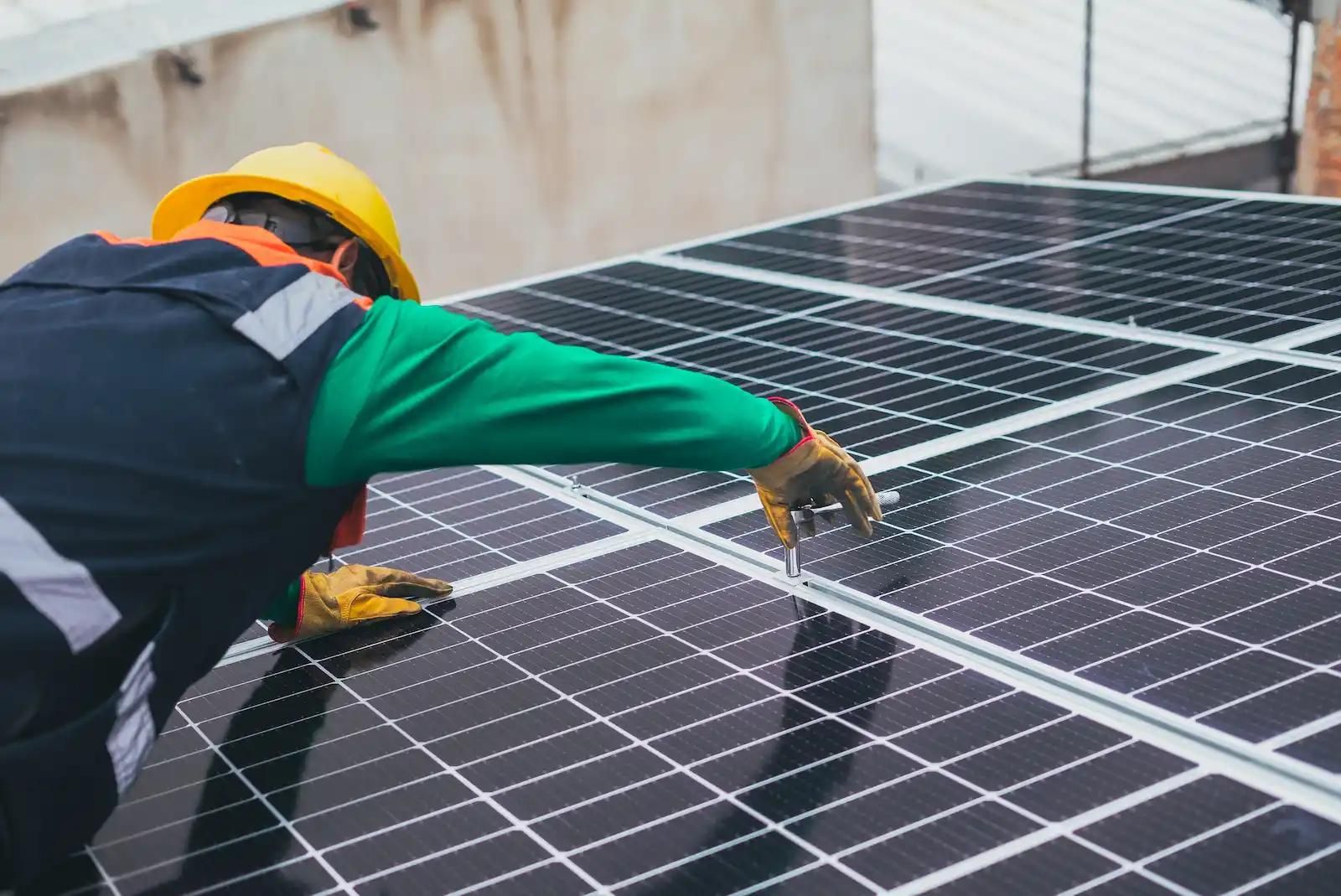 Eine Photovoltaikanlage wird von einem Installateur auf einem Dach montiert