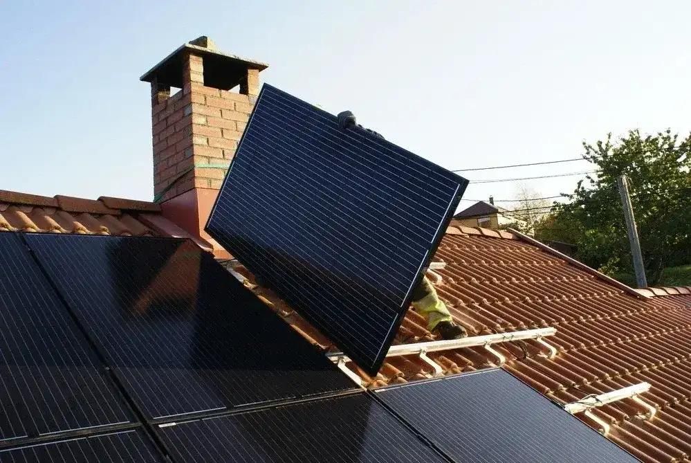 Dach mit Solarmodule und Installateur bei der Arbeit