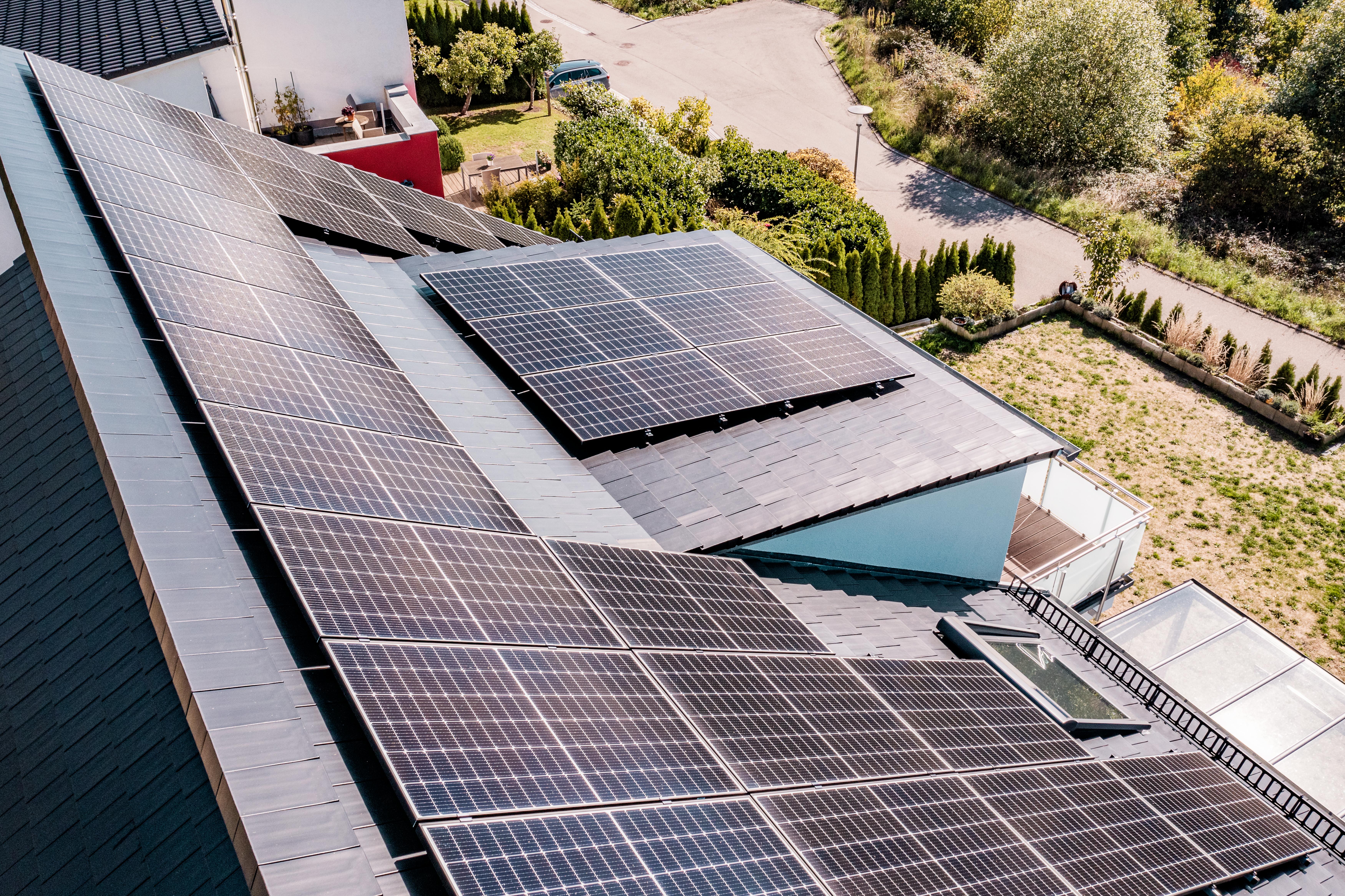 Gebäude mit Photovoltaikanlage mit schweizer Landschaft im Hintergrund